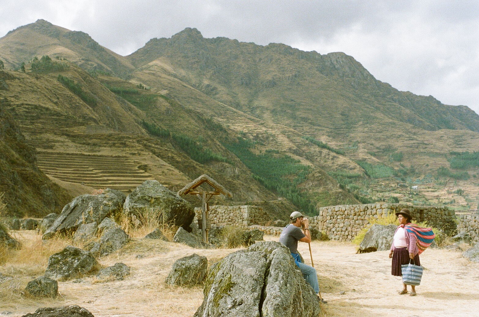 Image of a White tourist photographing and Indigenous woman in the highlands of Pisac.