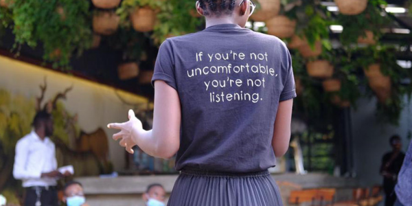 individual speaking with tshirt that says if you're not uncomfortable, your're not listening